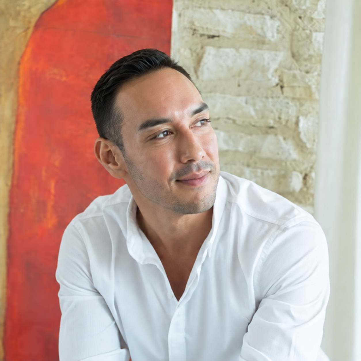 Retrato de Adrián Guerra, fundador de Styling Trio, con camisa blanca y actitud relajada