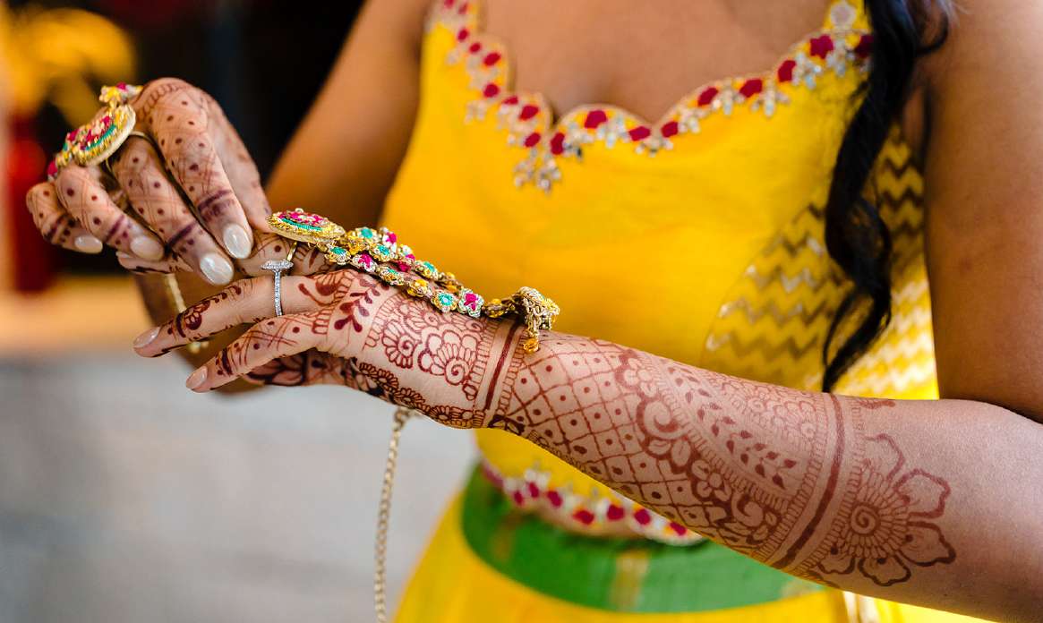 Floral henna flowing across a bride's hand and forearm